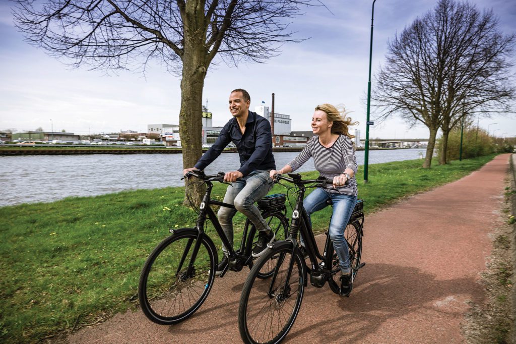 man en vrouw fietsen langs een vaart op een Giant fiets